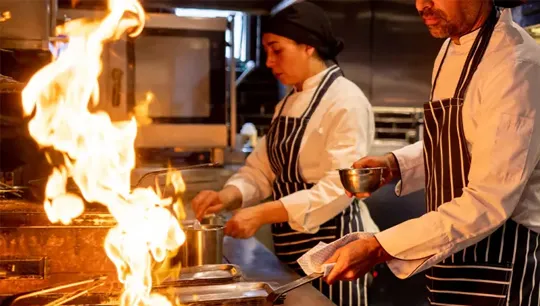 Chefs cooking in an industrial kitchen