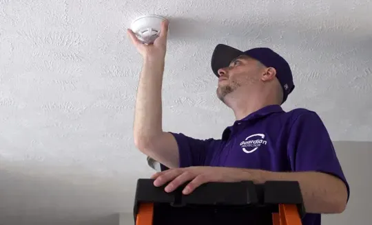 Guardian Protection employee installing a smoke & heat protector