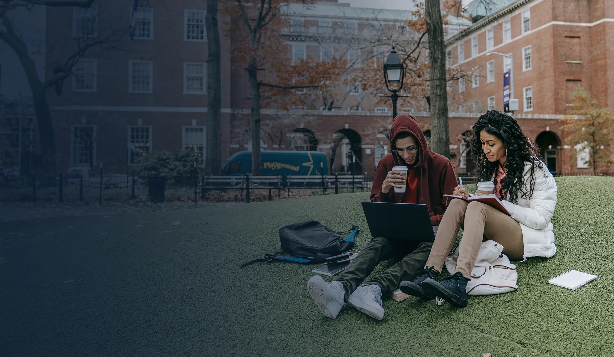College students studying on a campus lawn.