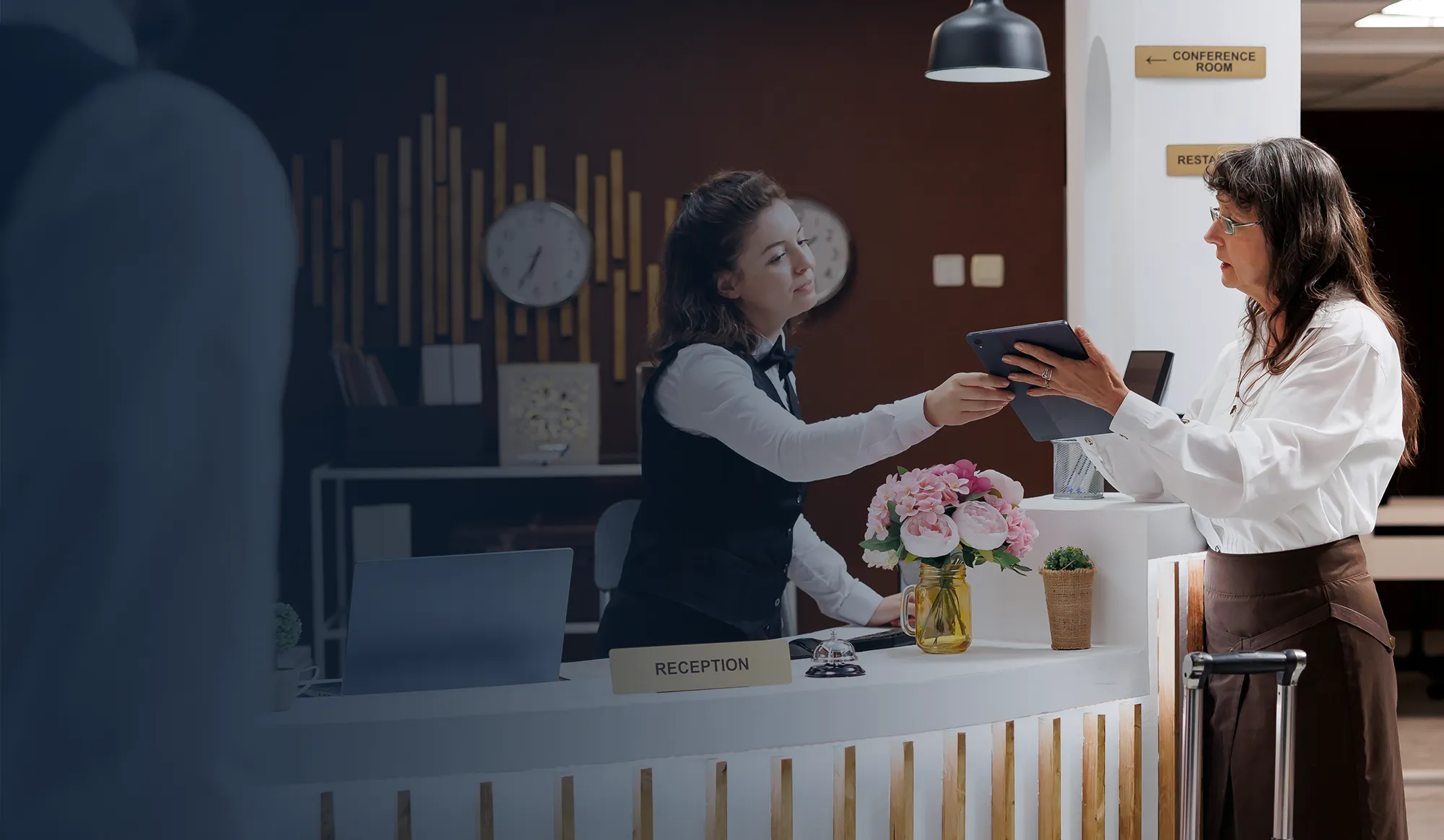 Hotel lobby with front desk and guests checking in.