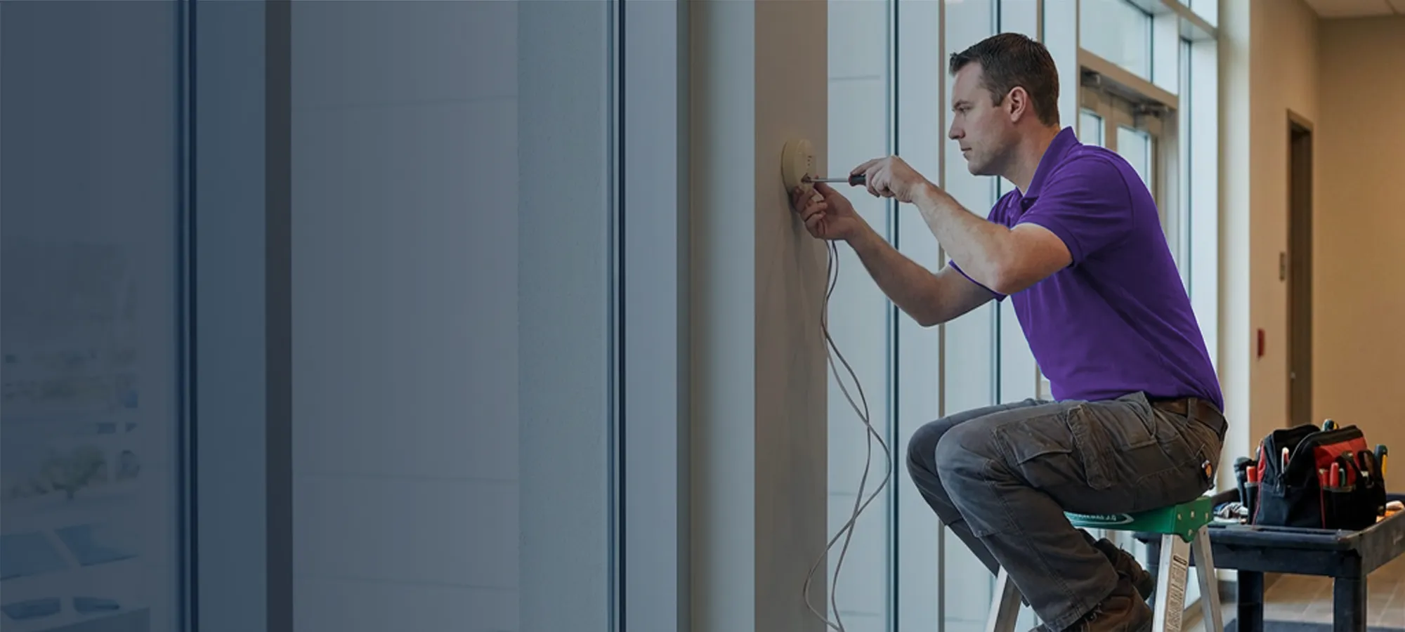 Security professional installing an intrusion detection sensor.