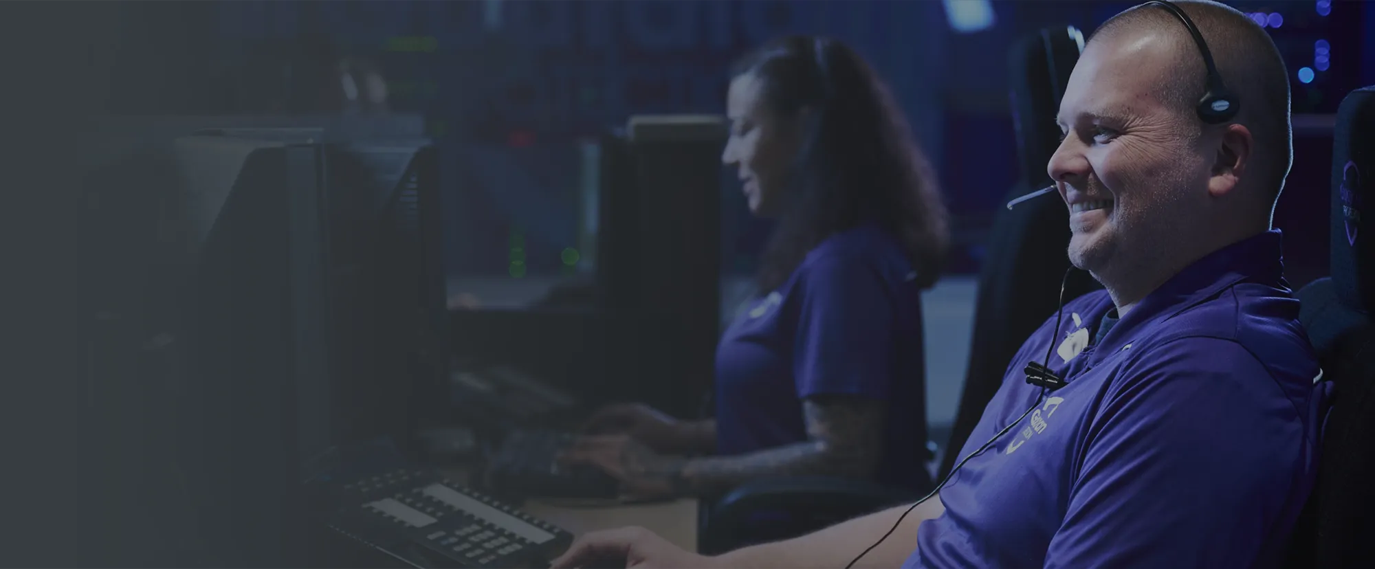 Man sitting at a table in a restaurant working on a laptop computer.
