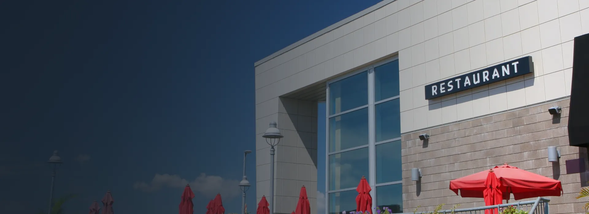 Exterior of a restaurant with outdoor seating and umbrellas