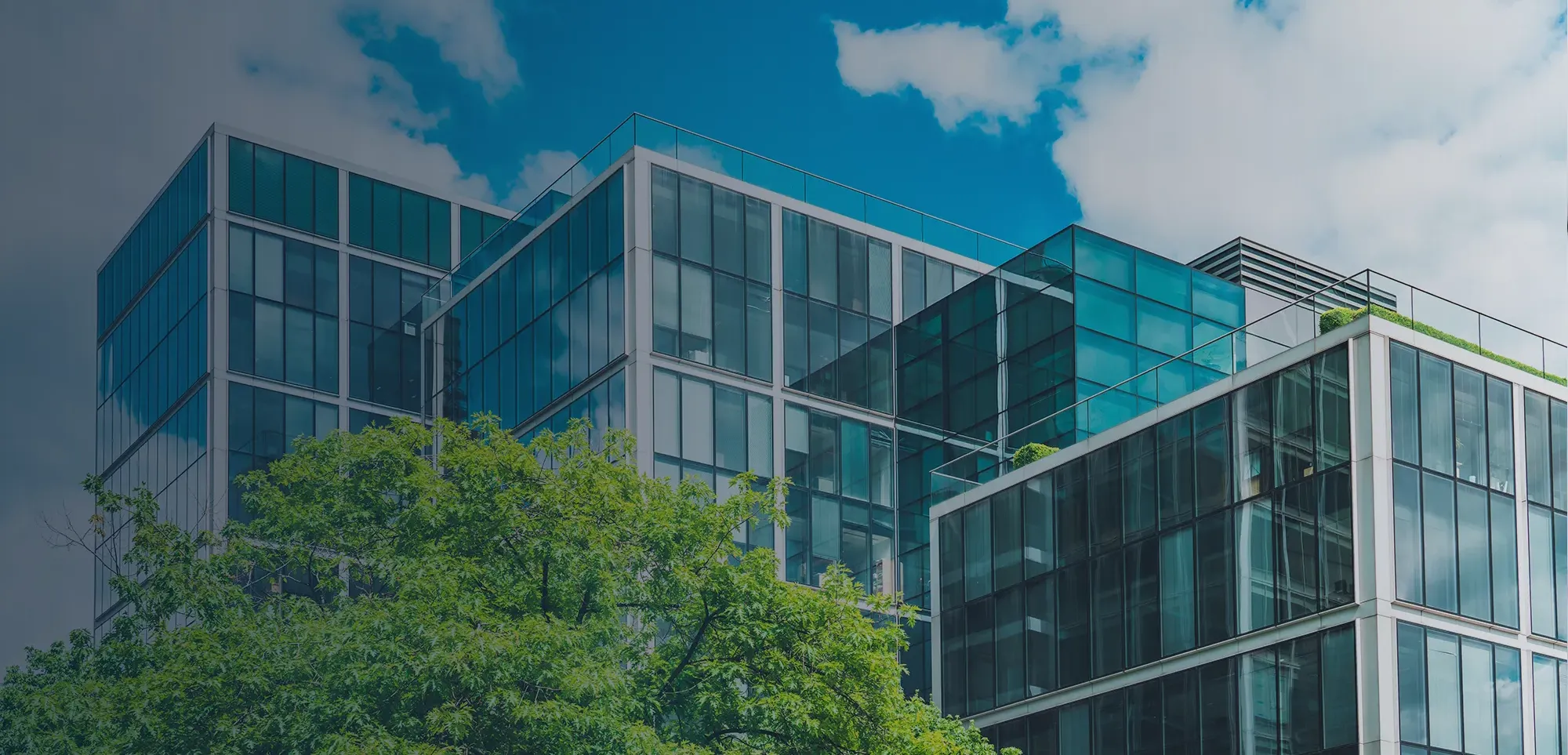 Photo of a large office building with the sun setting in the background.