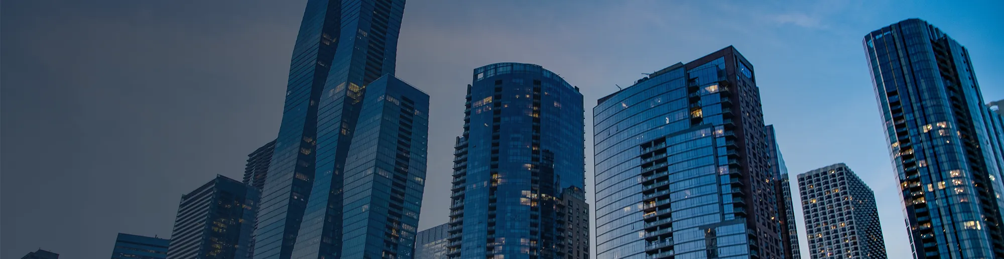 Photo of tall modern office buildings at dusk.