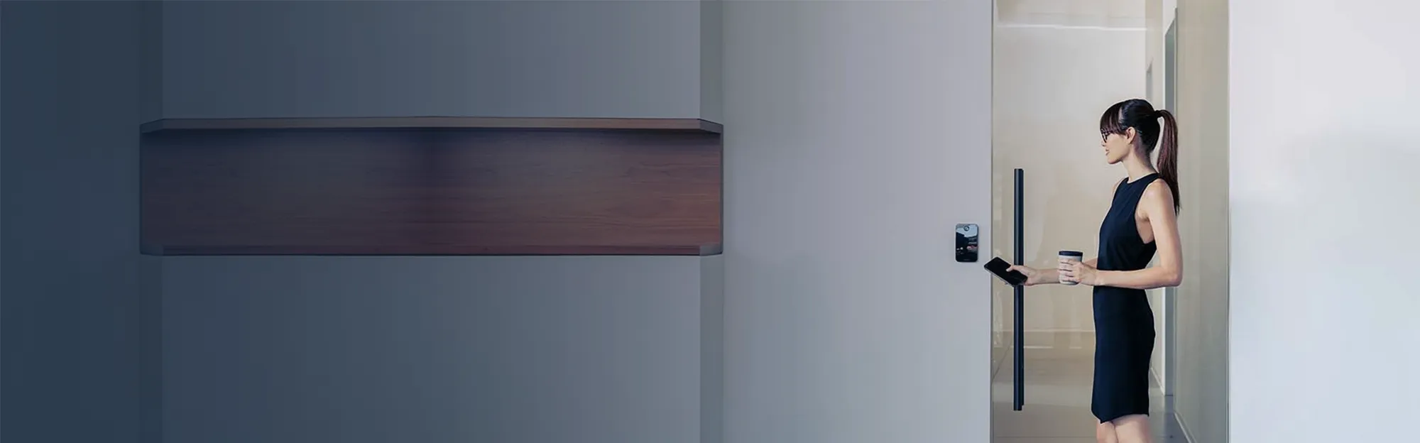 Woman in a modern office building using an app on her smart phone to gain access to a part of the building.