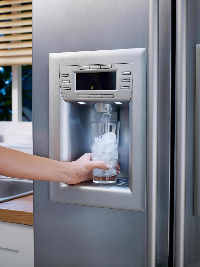 Person using the ice machine on a refrigerator door