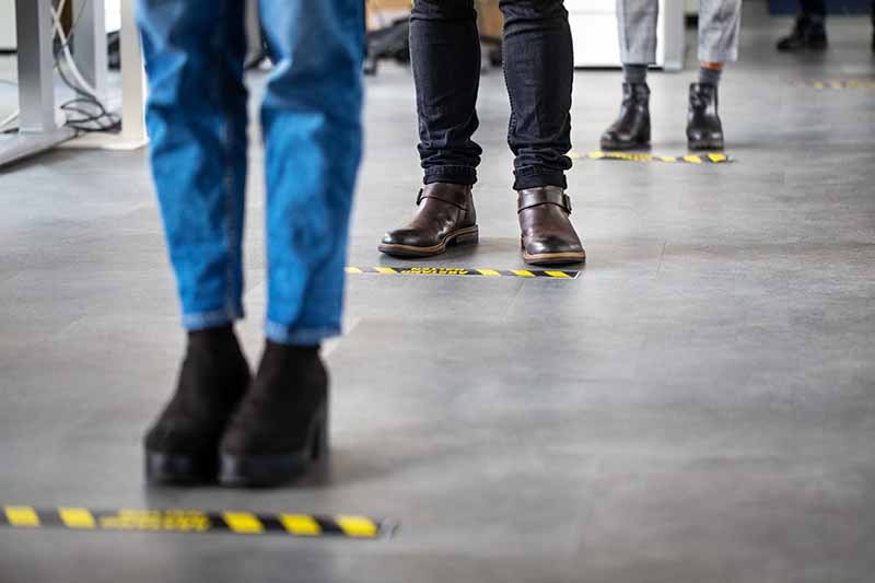 Three people standing socially distanced in a line