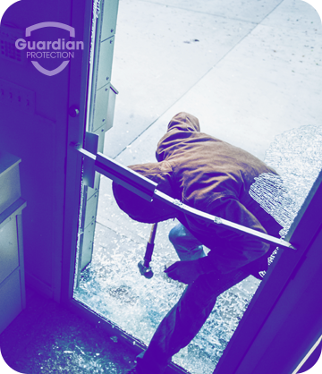 Burglar crawling through broken glass door