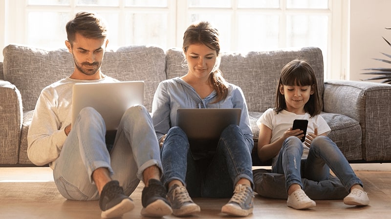 Family of three each using a smart device