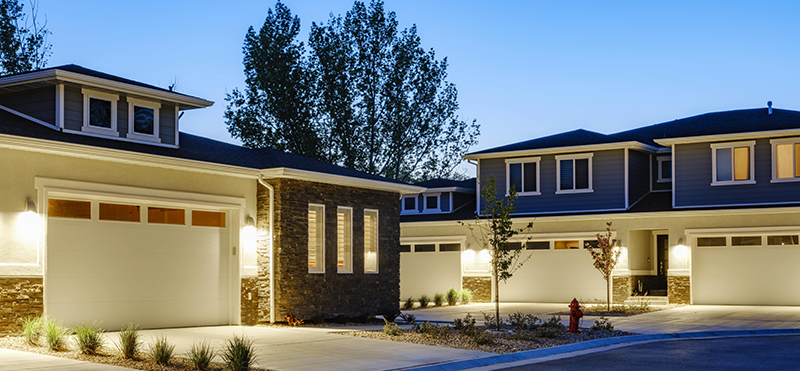 A row of townhomes with porch light sensors turned on