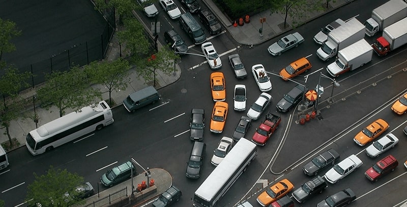 An aerial view of cars in traffic at busy city intersection