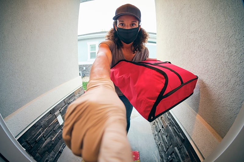 View from video doorbell camera of a woman delivering pizza