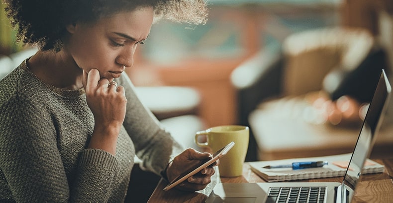 Woman checking Guardian Protection home security mobile app on smart phone