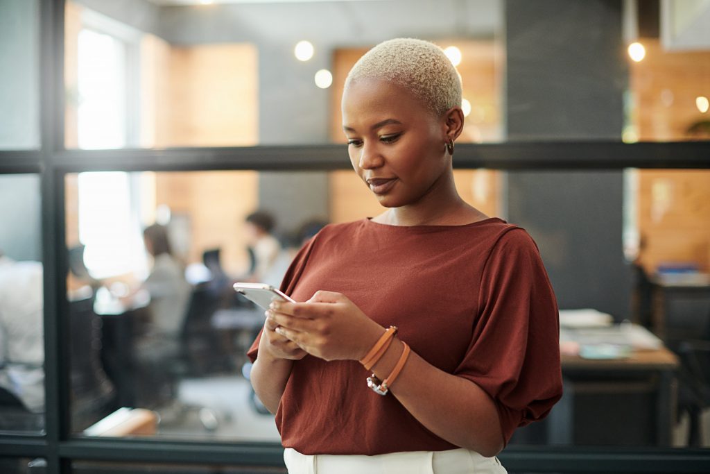 Image of a woman checking her phone for home security notifications