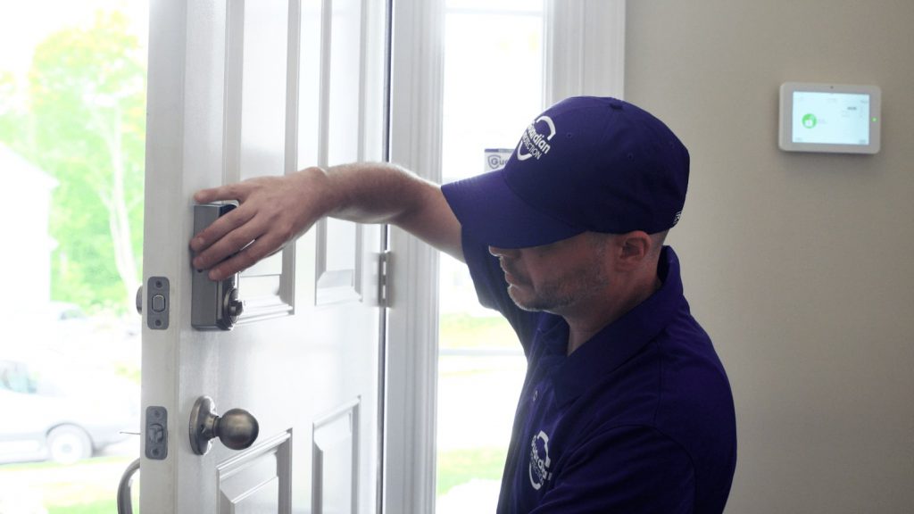 Guardian Protection technician installing a smart lock