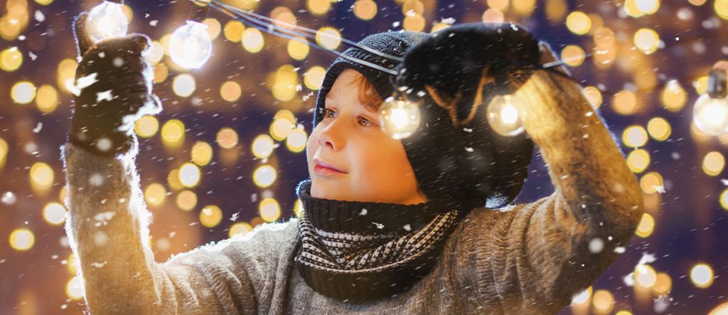 Niño mirando las luces navideñas alimentadas por los enchufes inteligentes de Guardian Protection