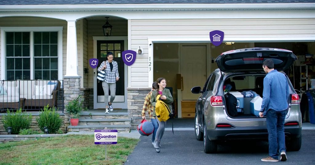 Family loading up their car as they're  shown being protected by Guardian Protection devices