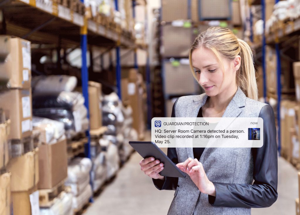 Woman checking security camera notification from tablet