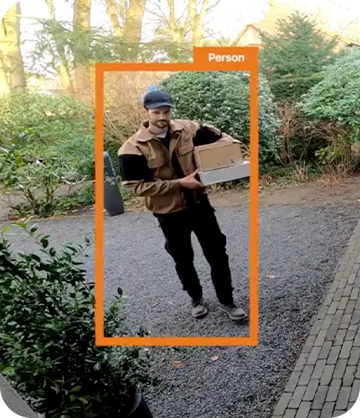 A man delivery man dropping off a package as seen through the video doorbell