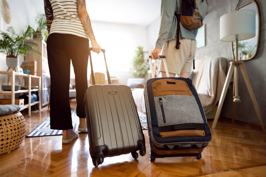 Two people with suitcases entering their vacation rental property 