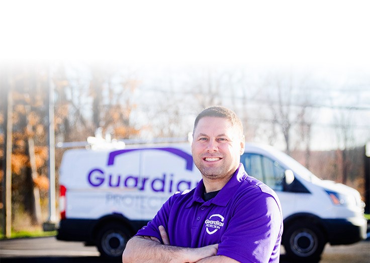 Guardian Protection Installation Technician standing in front of a van