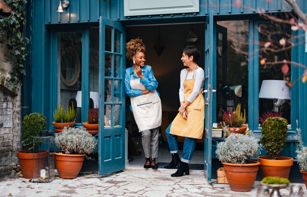 Two business owners laughing outside of their store protected by Guardian Protection business security