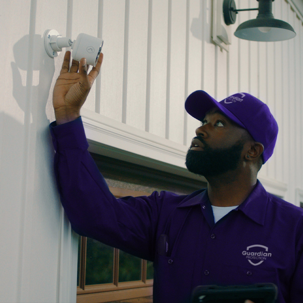 Guardian Protection professional technician installing an outdoor security camera for a home