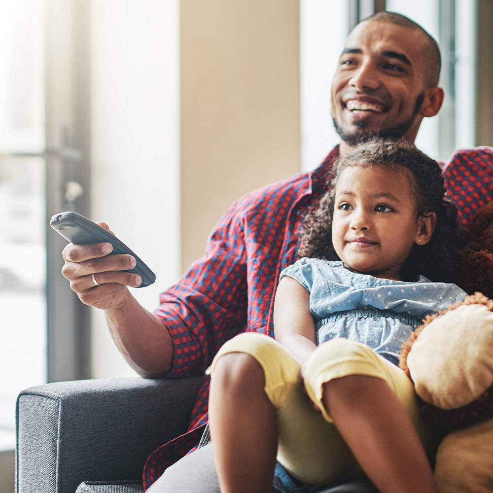 Father and child watching television using Guardian Protection's smart connections