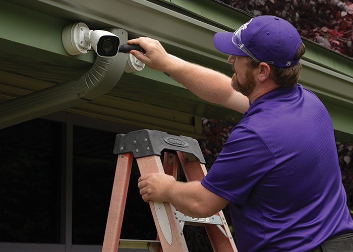 Guardian Protection professional technician installing an outdoor camera of a business security system