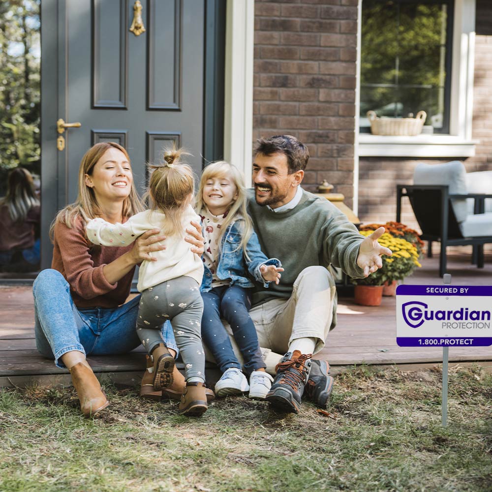 Family sitting on the porch with a Guardian Protection yard sign