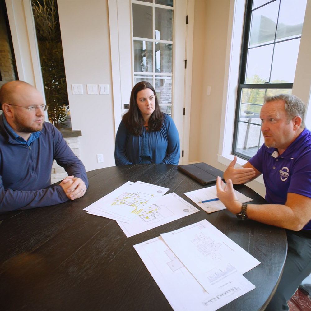 Guardian Protection Home Technology Specialist sitting at a table with couple purchasing new home