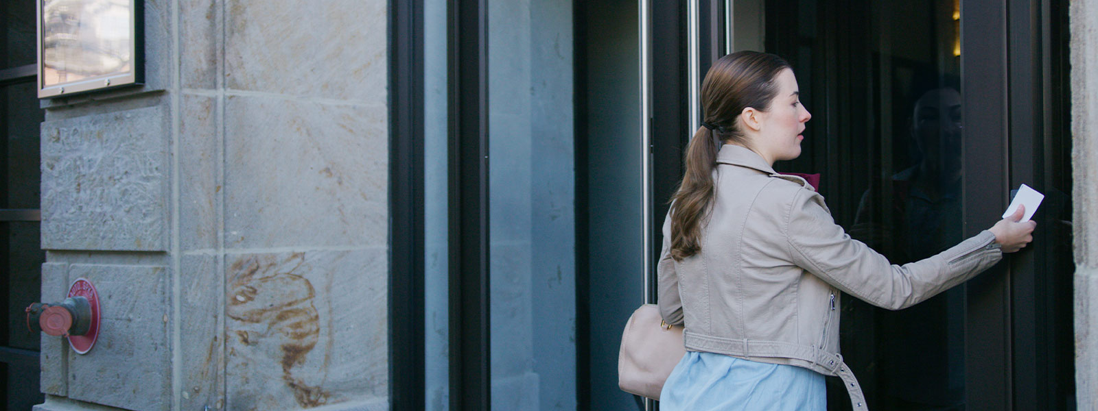 Woman using Guardian Protection's access control to get into a building