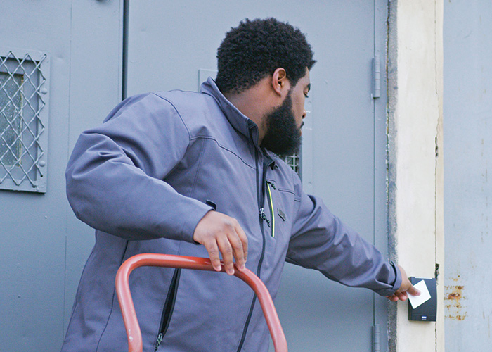 Man using Guardian Protection access control system to enter a building