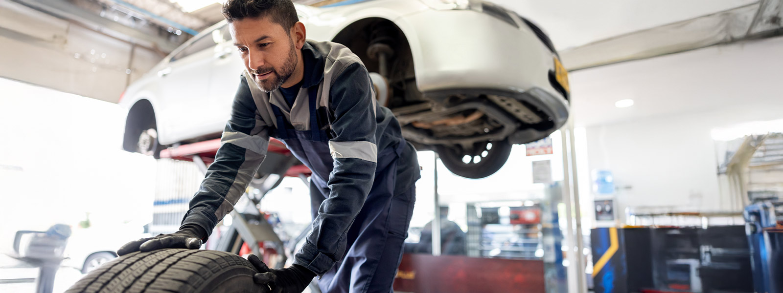 Man working in auto body shop with Guardian Protection Automotive Services Security Systems