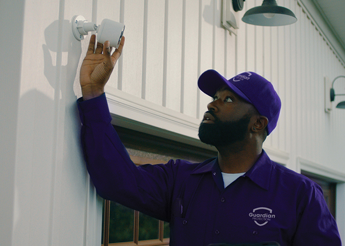 Guardian Protection technician installing a business security camera