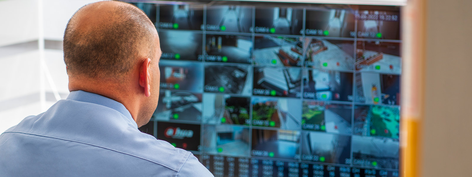 Man checking bus business's video surveillance feeds