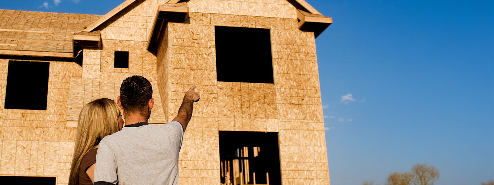 Couple looking up at their new home being built