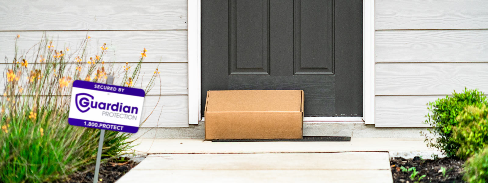 Package delivered on home's doorstep with Guardian Protection yard sign