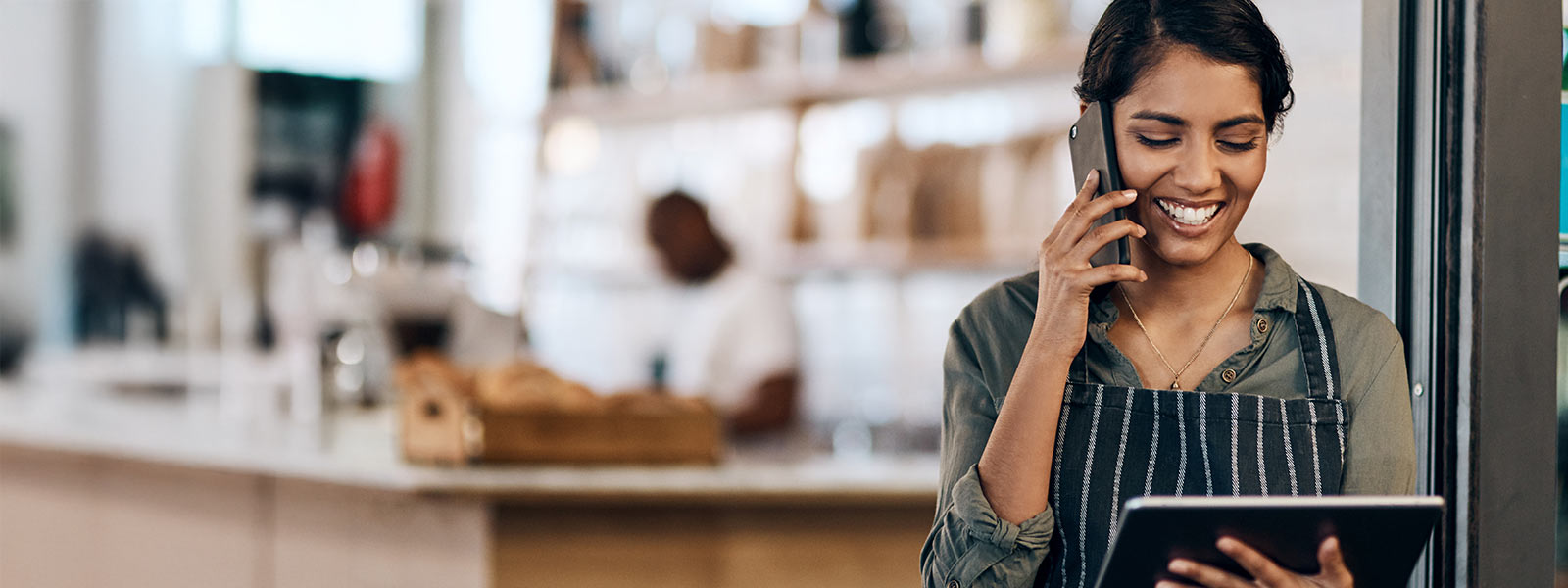 Store owner on phone holding an iPad