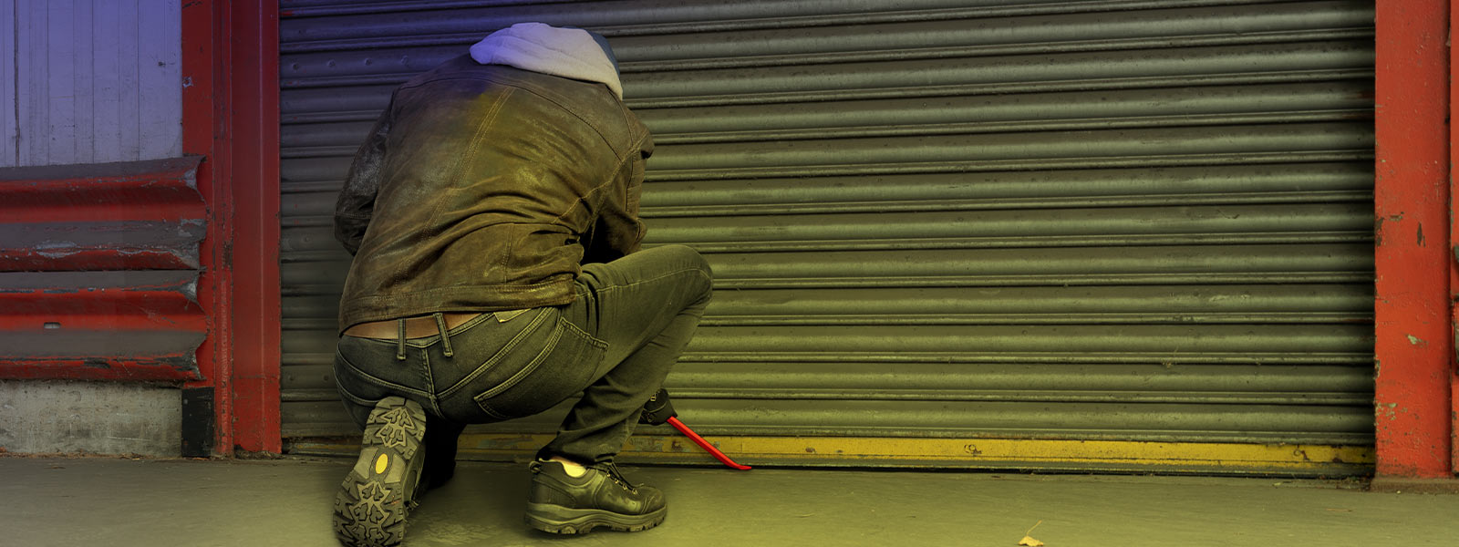 Intruder breaking in to store's overhead door