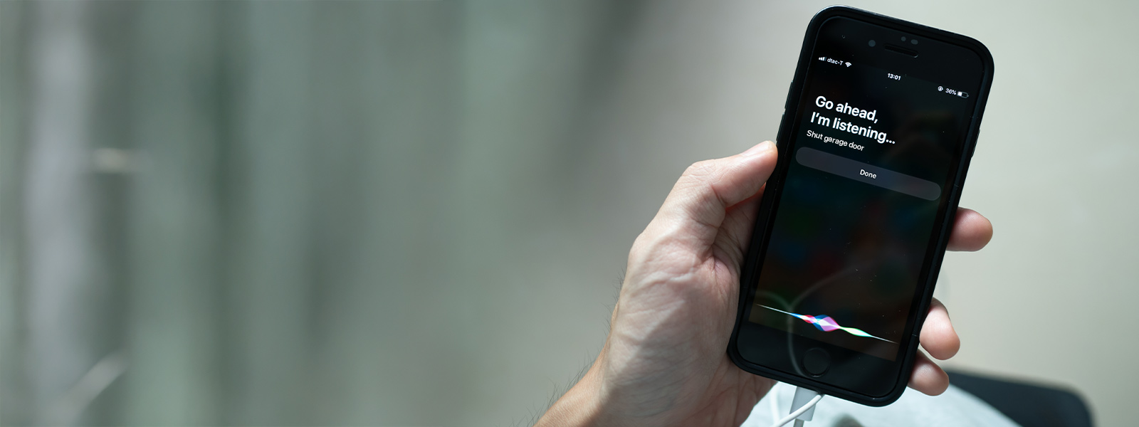 Hand holding a smartphone with a garage door voice command on the screen